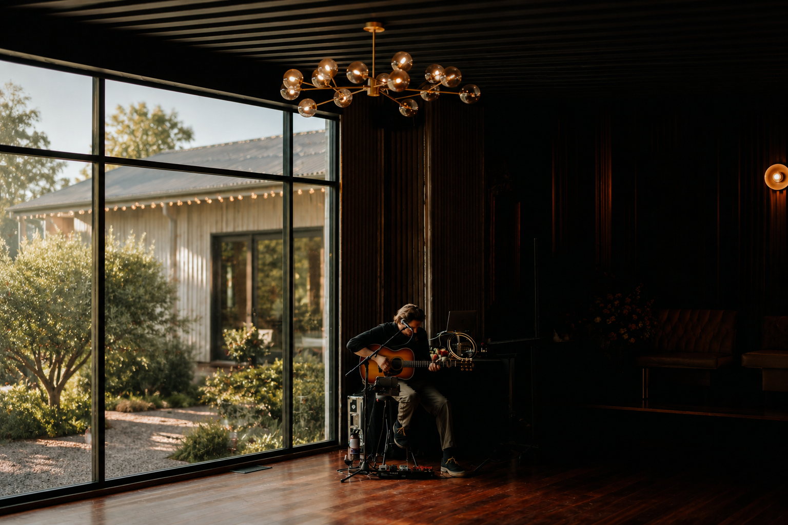 Solo acoustic musician playing guitar quietly by a window