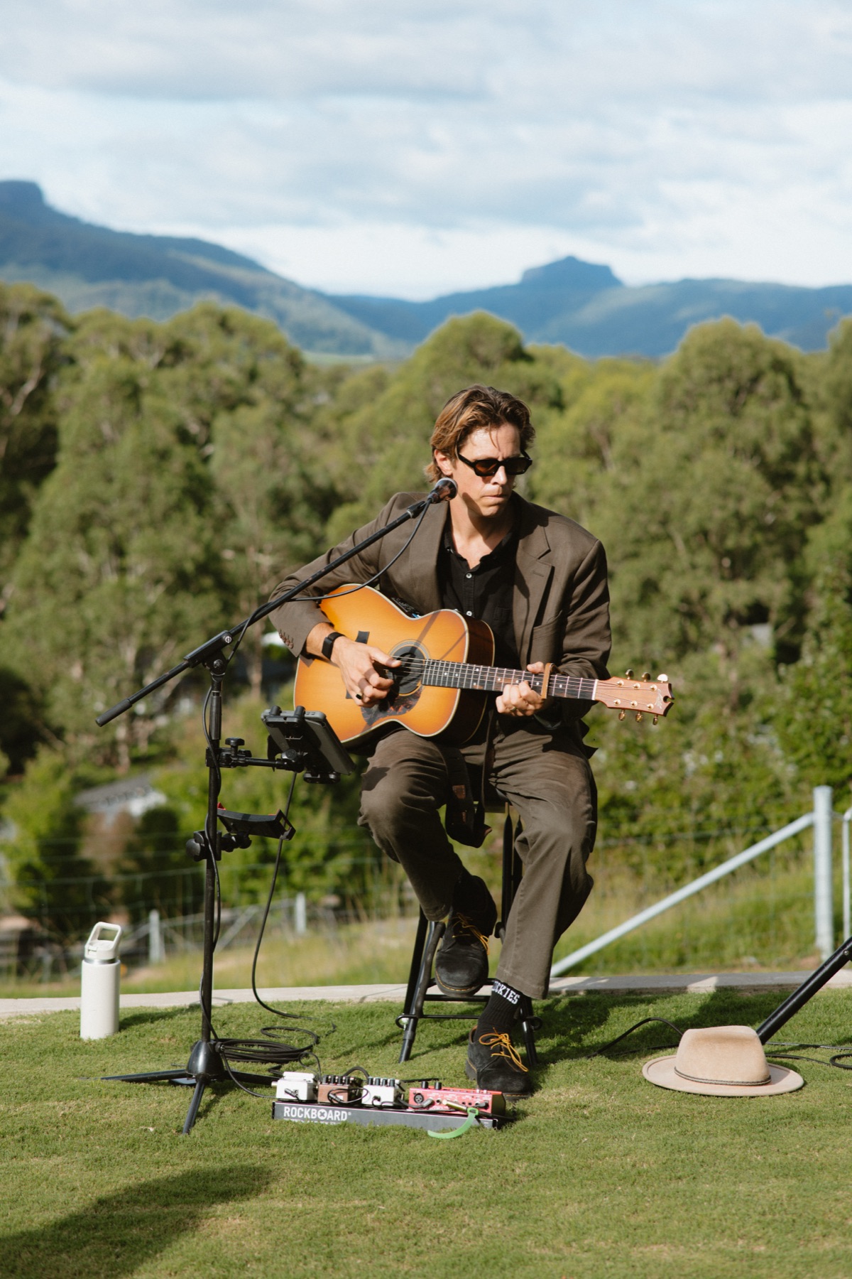 Solo acoustic musician performing with the Southern Highlands in the background